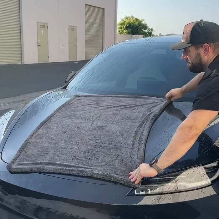 Open the towel fully and lay it flat across the roof or hood.